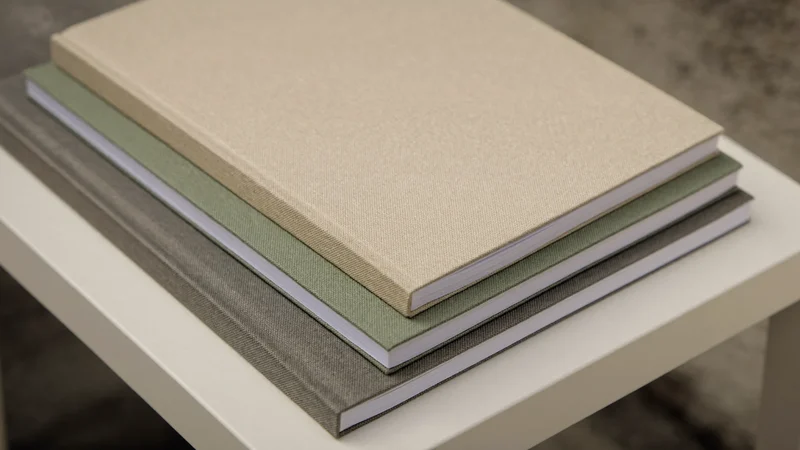 Pile de trois carnets en lin sable, sauge et charbon