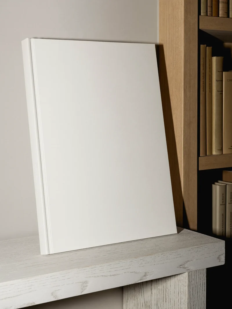 Grand livre d'art à couverture vierge, appuyé sur un socle bas